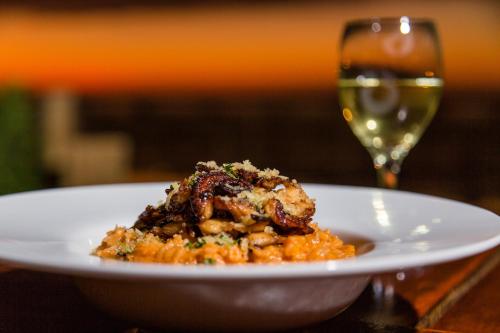 a white plate of food with a glass of wine at Hoja de Palma Bungalows in Canoas De Punta Sal