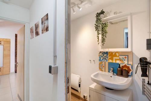 Un baño blanco con lavabo y espejo. en Loft Sven, en Baden-Baden