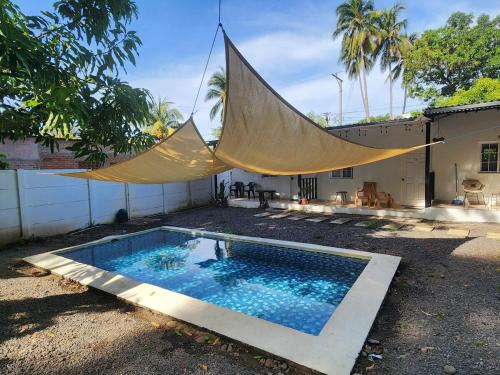 una piscina con mosquitera en un patio trasero en Sunzal Loft, WSL Ecovilla Surfing, en El Sunzal