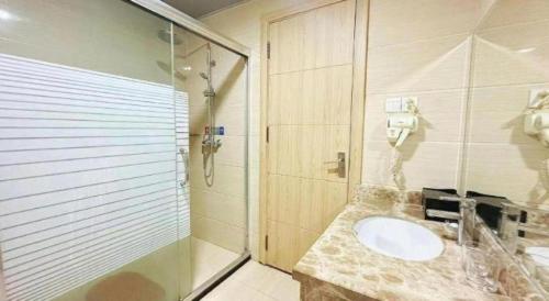 a bathroom with a sink and a shower at Bashan Hotel in Xiamen