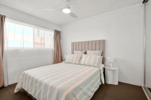 a white bedroom with a bed and a window at Kailoha Unit 8, 27 Canberra Tce, Kings Beach in Caloundra
