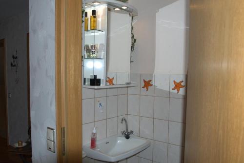 BorkenにあるFerienwohnung Gabiの洗面台と鏡のあるバスルーム