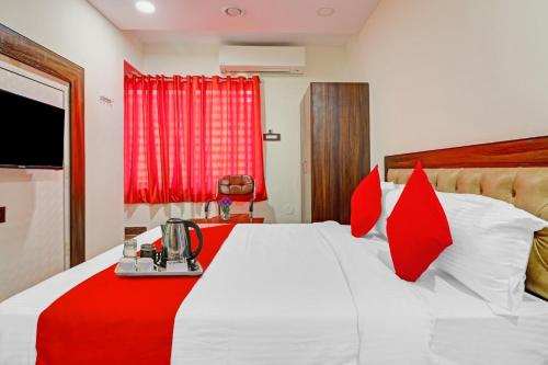 a hotel room with a bed with red pillows at Heavens Inn Near Rasoolpura metro station in Secunderabad