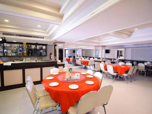 a dining room with a red table and chairs at Cathay Hotel in Betong