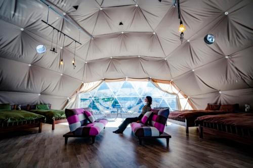a woman sitting in a room in a tent at フォレスタ阿蘇車帰 in Aso