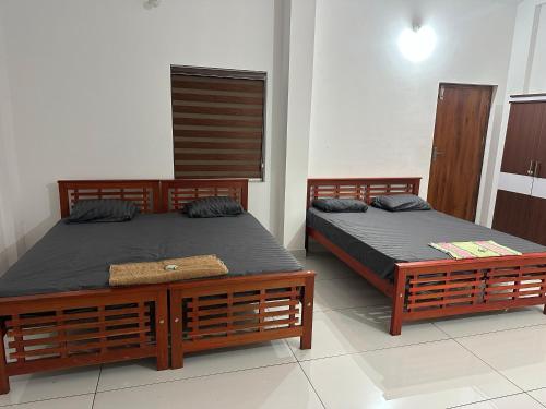 two beds sitting in a room withermottermottermott at Barkka in Ponnāni