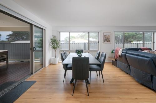 een eetkamer met een tafel en een bank bij Villa Tranquillità in Venus Bay