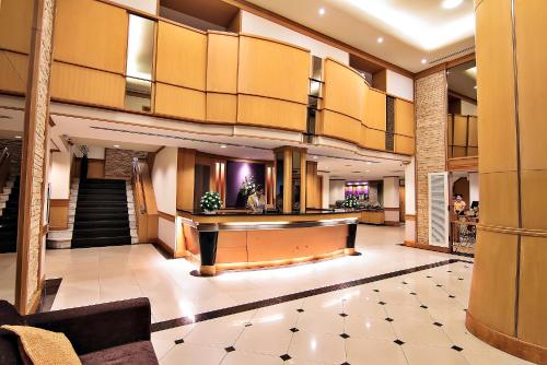 a lobby of a hotel with a piano at Bossotel Bangkok in Bangkok