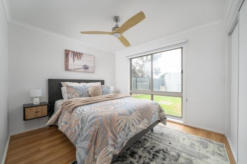 een slaapkamer met een bed en een groot raam bij Villa Tranquillità in Venus Bay