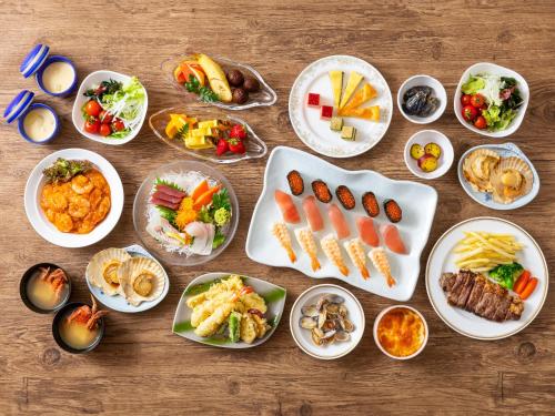 a group of plates of food on a wooden table at Mikazuki Sea-Park Hotel Awa Kamogawa in Kamogawa