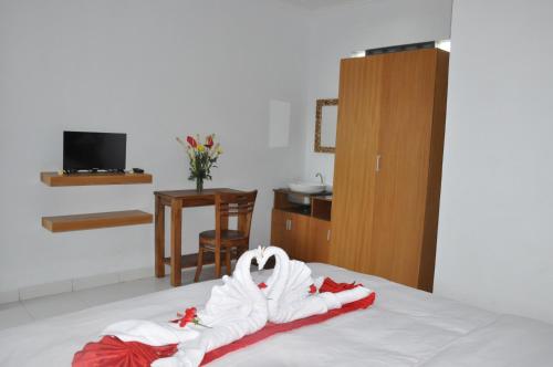 Una habitación de hotel con una cama con toallas. en Bubu Inn, en Ubud