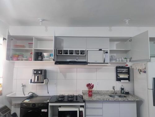 a kitchen with white cabinets and a stove at Apto inteiro 600mts do Hospital de Amor in Barretos