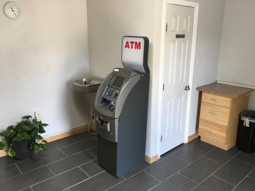 une machine à atm dans une pièce à côté d'une porte dans l'établissement Cajun Country Inn, à Gonzales