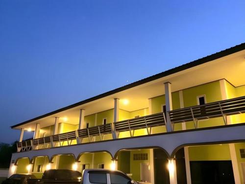 un bâtiment avec des voitures garées dans un parking dans l'établissement Saraburi Garden Resort, à Ban Kluai