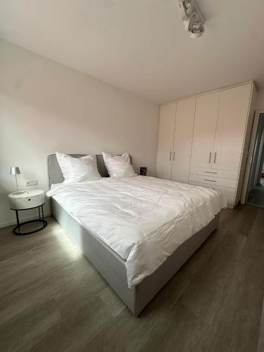 a bedroom with a large white bed and a table at Appartement in Top Lage - kein Lift vorhanden! in Dornbirn