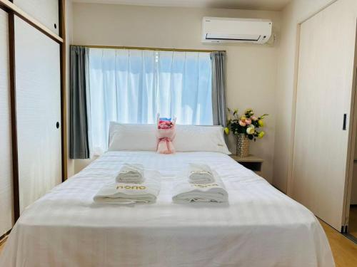 a bedroom with a bed with two towels on it at Nono in Takamatsu