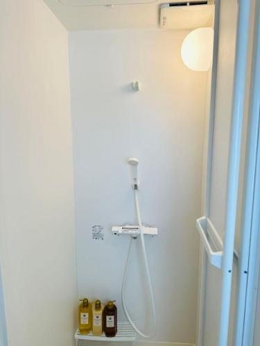 a white shower in a bathroom with a hose at Nono in Takamatsu
