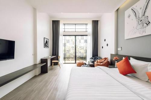 a hotel room with a large bed and a television at PIMDARA HOTEL in Ban Kaeo