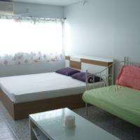 a room with two beds and a couch and a table at T8 Guest House Don Mueang Challenger in Bangkok