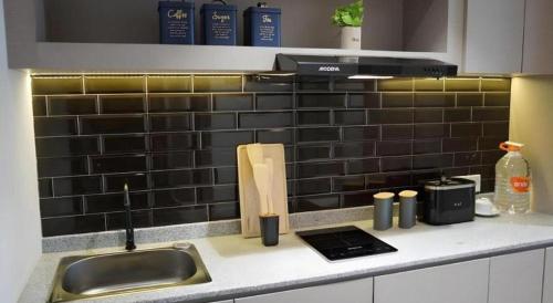 - un comptoir de cuisine avec un évier et un comptoir dans l'établissement The Day Residence, à Jakarta