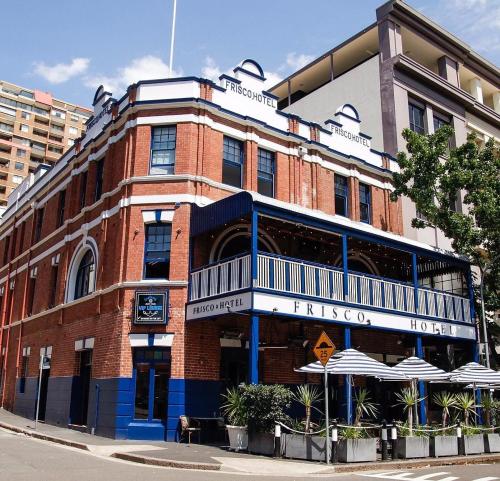 a red brick building with umbrellas in front of it at Frisco Hotel in Sydney