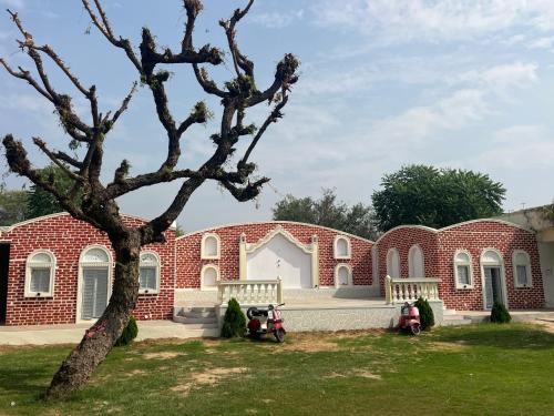 a brick building with two motorcycles parked in front of it at Hotel Ajitgarh in Jhunjhunūn