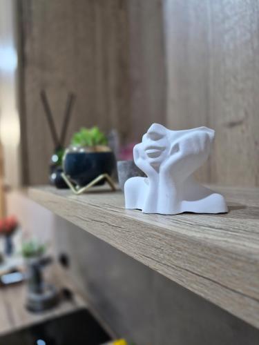 a white sculpture of a dog sitting on a shelf at Love Nest in Almaty