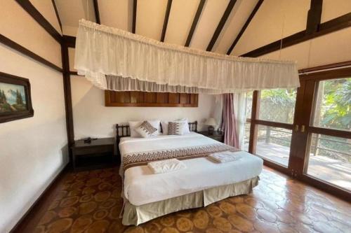 a bedroom with two beds and a large window at Phuingfah in Ban Tai