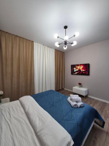 a bedroom with a bed with two towels on it at Love Nest in Almaty