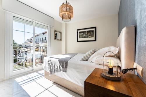 a bedroom with a bed and a table with a candle at Mirage Mijas centro in Mijas