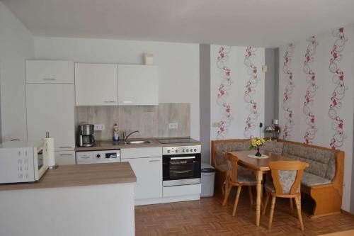 a kitchen with white appliances and a table with chairs at Ferienwohnung Meins in Friesoythe
