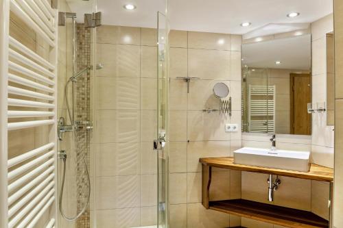 a bathroom with a glass shower and a sink at Apart Erna in See