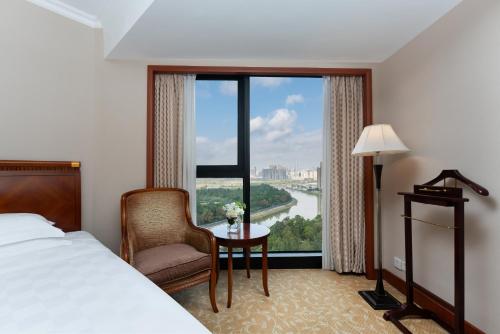 a hotel room with a bed and a chair and a window at Felicity Hotel Shenzhen, Luohu Railway Station in Shenzhen
