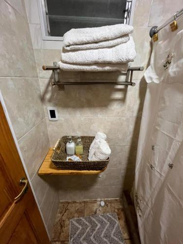 ein Badezimmer mit einem Regal mit Handtüchern und Kerzen in der Unterkunft Complejo San isidro in San Rafael