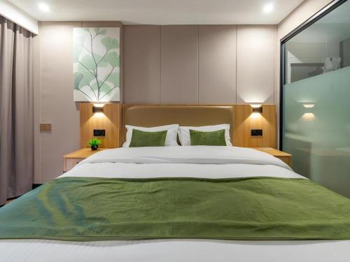 済寧市にあるGreenTree Inn Jining Jianshe Road Hotelのベッドルーム1室(大型ベッド1台、緑のシーツ、枕付)