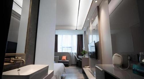 a bathroom with a tub and a sink in a room at GreenTree Inn Meizhou Meijiang District Wanda Plaza Hotel in Meizhou