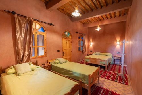 a bedroom with two beds in a room at Riad Imuhar Prestige - Mhamid Desert Retreat in Mhamid