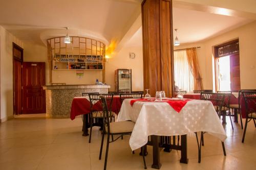 une salle à manger dotée d'une table avec des nappes rouges et blanches dans l'établissement Northern Galaxy Hotel, à Isiolo