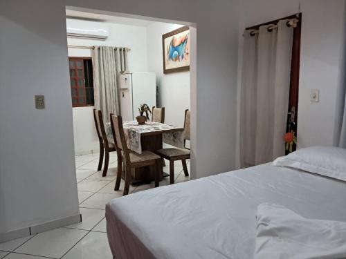 a bedroom with a bed and a table and chairs at kitnet Ceu in Campo Grande