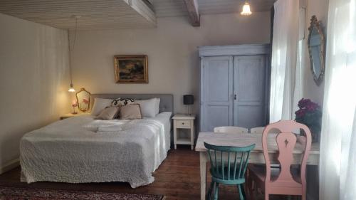 a bedroom with a bed and two chairs at City Park Home in Pärnu