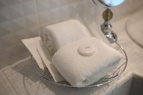 a basket of towels on a counter in a bathroom at RoomQuest Suvarnabhumi Airport Romklao Soi 6 in Lat Krabang