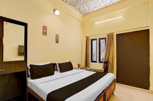 ジャイプールにあるHotel O Jagatpura Central Railway Station Jaipurの大きなベッドと窓のある寝室