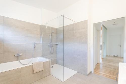 a bathroom with a shower and a bath tub at Haus Weigt - Appartement das Grüne in Mariapfarr