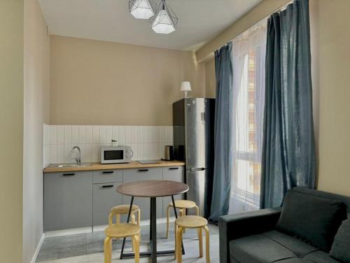 a kitchen with a table and chairs and a kitchen with a refrigerator at River Apart in Almaty