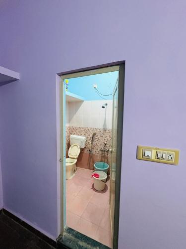a bathroom with a toilet and a purple wall at Sreeram house-2bhk flat near Bannerghatta in Kammasandra