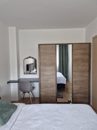 a bedroom with a large wooden closet with a mirror at Hari Apartmani Oaza in Tuzla