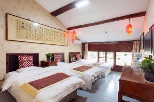 a bedroom with three beds and a desk at Pingyao Yufengheng Hotel in Pingyao