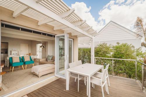 ジョージにあるPalms Manor on Kingswood Golf Estateのパティオ(白いテーブル、デッキの椅子付)