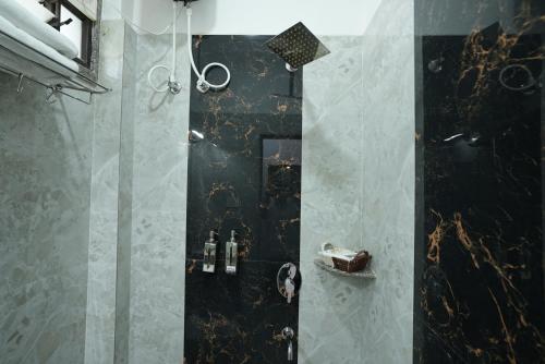 baño con ducha de color negro en Utsav Hotels and Banquets Bolpur, en Bolpur