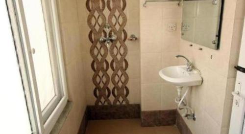 a bathroom with a sink and a shower with a mirror at De Hotel Veda in Kathmandu